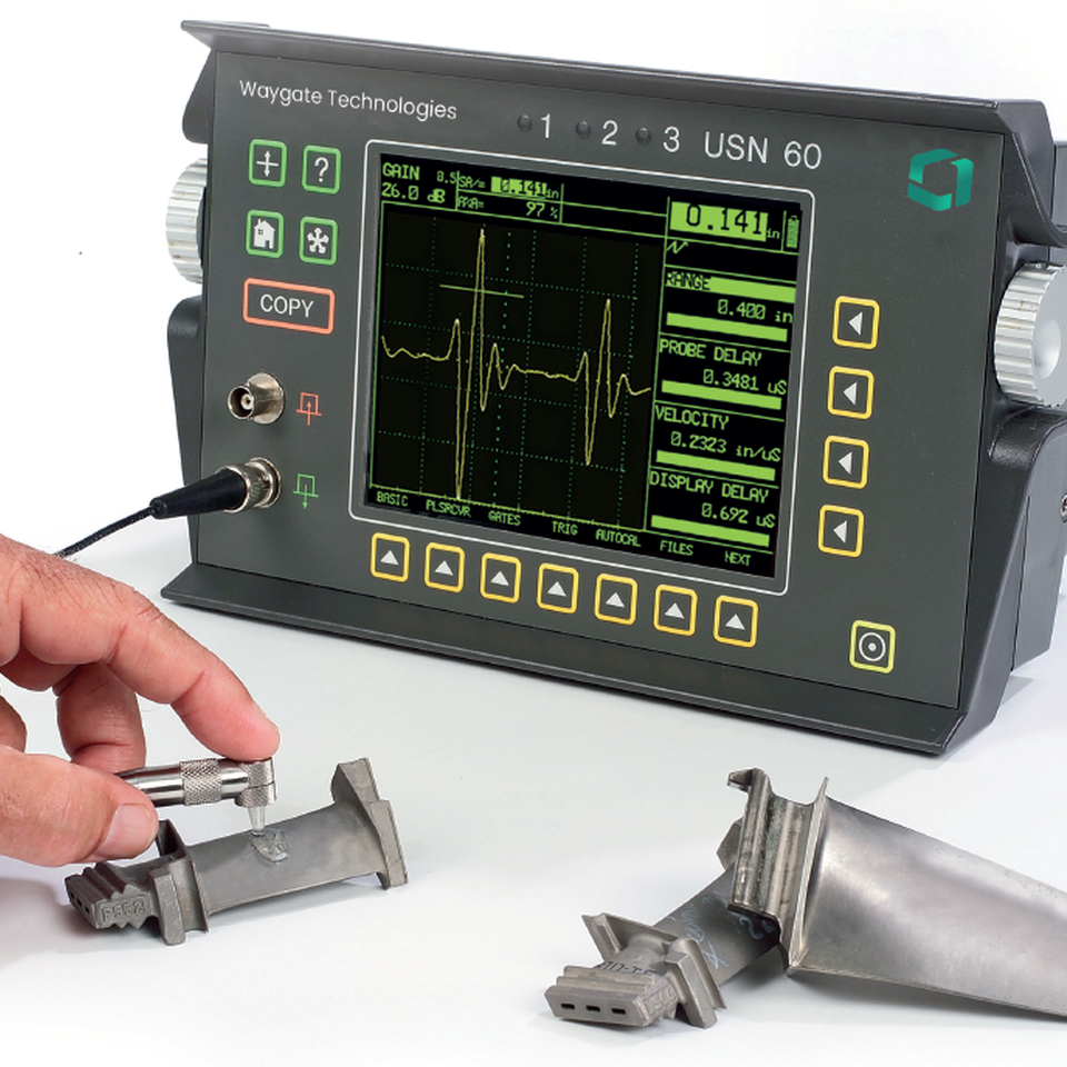 man using USN 60 ultrasonic flaw detector to inspect small metal piece