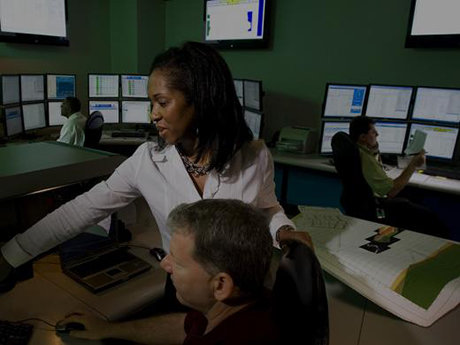 Photo of two Baker Hughes employees looking at computer screens